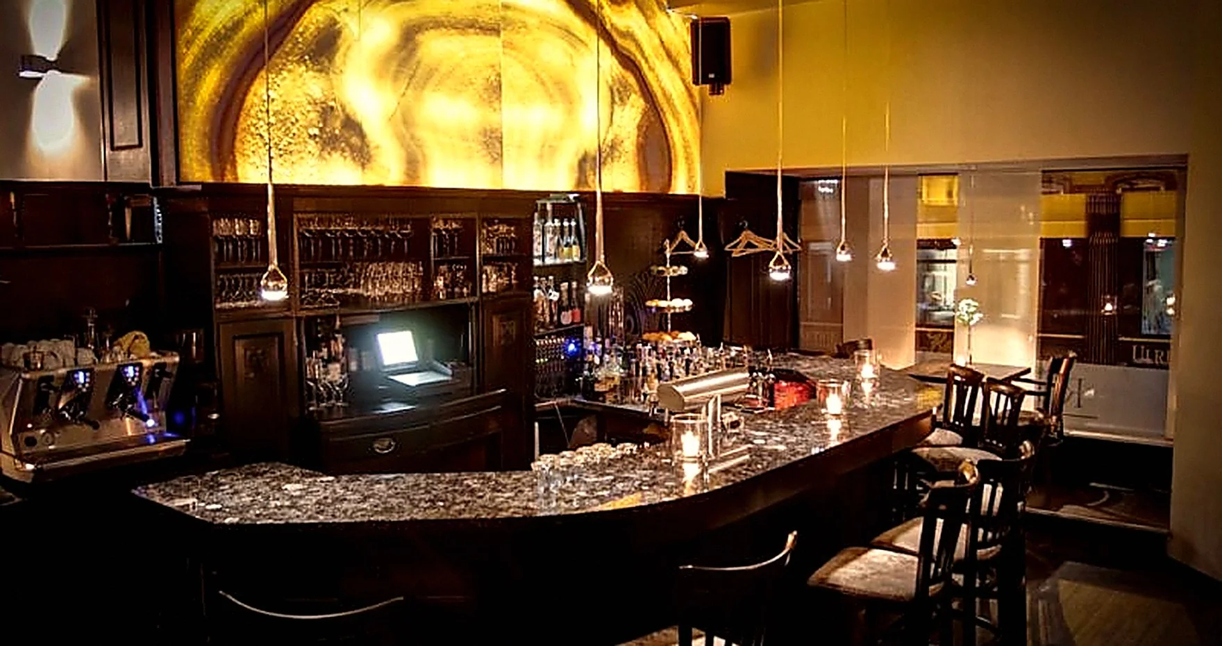 Die Bar des Restaurant ROOM mit hinterleuchteter Onyx-Wand und Granittresen